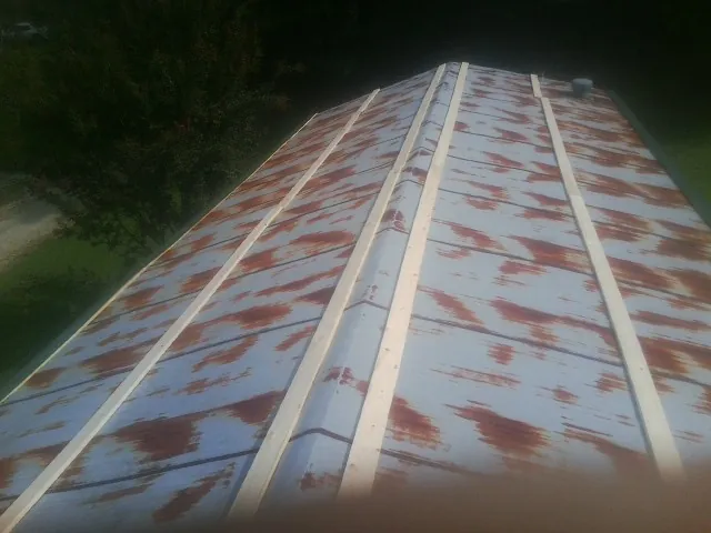 Rusted metal roof panels with new wood purlins before replacement — Storm Damage Roof Repair in Saucier by Roofing Brothers